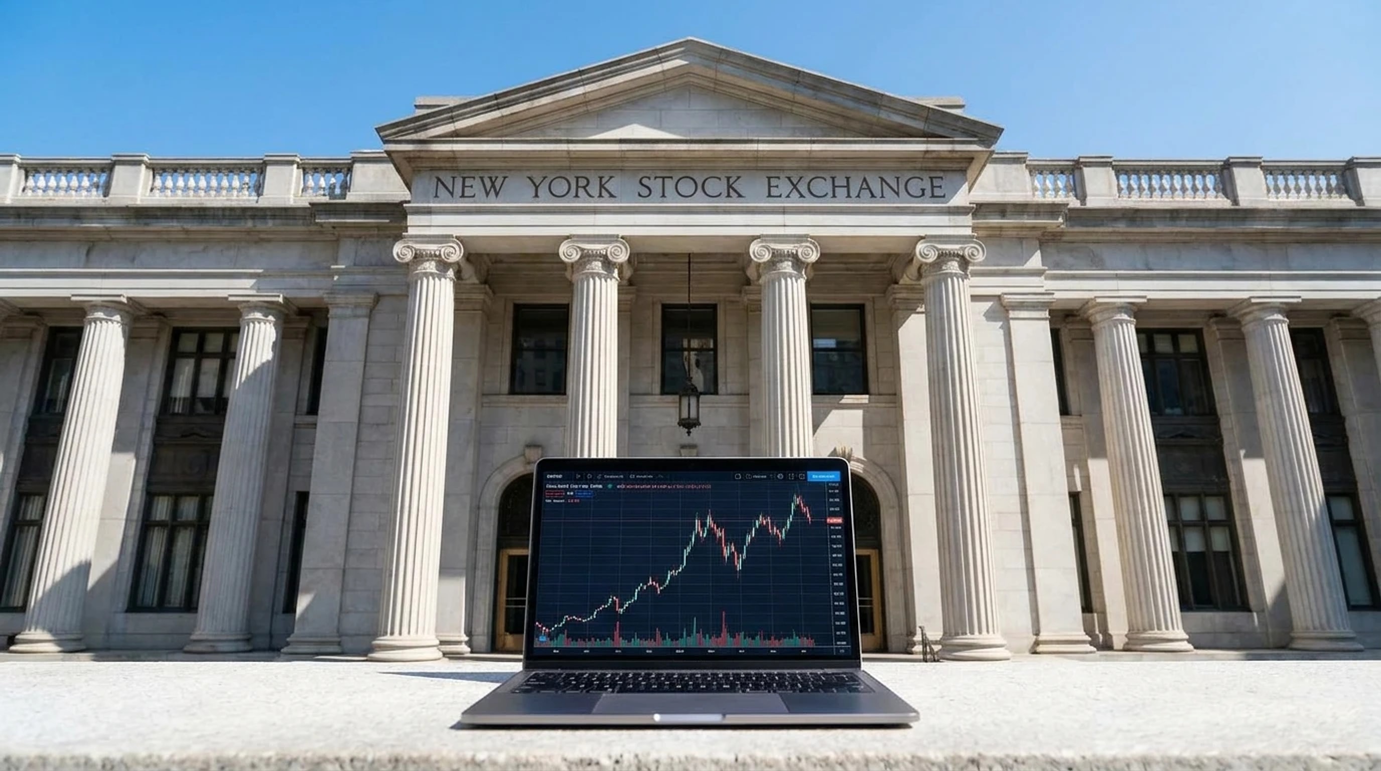 A laptop on the stone ledge in front of the New York Stock Exchange